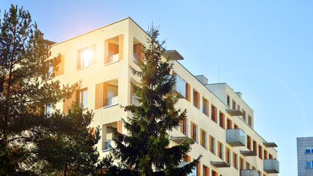 Apartment building with symmetrical modern architecture in the city. Modern apartment building on a sunny day. Facade of a modern apartment building. Bottom view.の写真素材