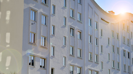 Apartment building with symmetrical modern architecture in the city. Modern apartment building on a sunny day. Facade of a modern apartment building. Bottom view.の写真素材