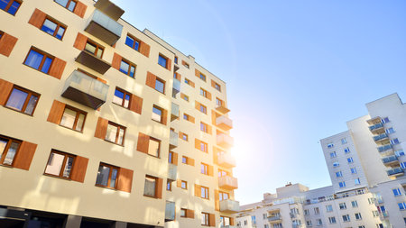 Apartment building with symmetrical modern architecture in the city. Modern apartment building on a sunny day. Facade of a modern apartment building. Bottom view.の写真素材