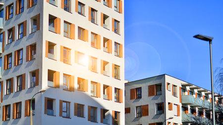 Apartment building with symmetrical modern architecture in the city. Modern apartment building on a sunny day. Facade of a modern apartment building. Bottom view.の写真素材