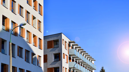 Apartment building with symmetrical modern architecture in the city. Modern apartment building on a sunny day. Facade of a modern apartment building. Bottom view.の写真素材