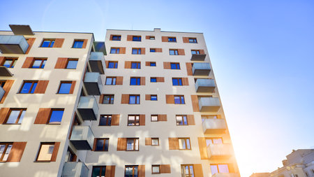 Apartment building with symmetrical modern architecture in the city. Modern apartment building on a sunny day. Facade of a modern apartment building. Bottom view.の写真素材