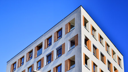 Apartment building with symmetrical modern architecture in the city. Modern apartment building on a sunny day. Facade of a modern apartment building. Bottom view.の写真素材