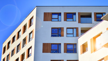 Apartment building with symmetrical modern architecture in the city. Modern apartment building on a sunny day. Facade of a modern apartment building. Bottom view.の写真素材