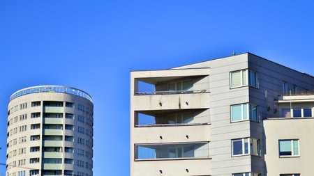 Apartment building with symmetrical modern architecture in the city. Modern apartment building on a sunny day. Facade of a modern apartment building. Bottom view.の写真素材