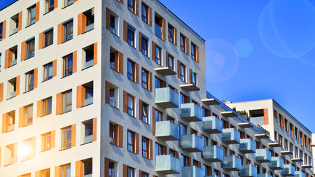 Apartment building with symmetrical modern architecture in the city. Modern apartment building on a sunny day. Facade of a modern apartment building. Bottom view.の写真素材