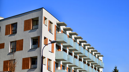 Apartment building with symmetrical modern architecture in the city. Modern apartment building on a sunny day. Facade of a modern apartment building. Bottom view.の写真素材