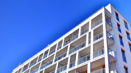 Apartment building with symmetrical modern architecture in the city. Modern apartment building on a sunny day. Facade of a modern apartment building. Bottom view.の写真素材