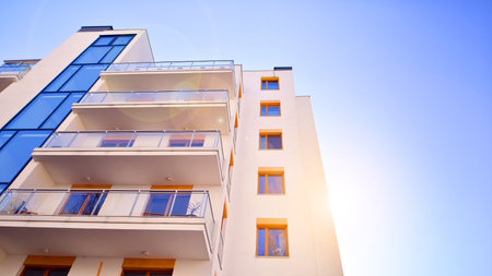 Apartment building with symmetrical modern architecture in the city. Modern apartment building on a sunny day. Facade of a modern apartment building. Bottom view.の写真素材