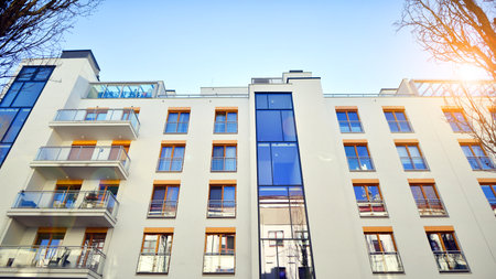 Apartment building with symmetrical modern architecture in the city. Modern apartment building on a sunny day. Facade of a modern apartment building. Bottom view.の写真素材