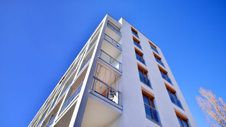 Apartment building with symmetrical modern architecture in the city. Modern apartment building on a sunny day. Facade of a modern apartment building. Bottom view.の写真素材