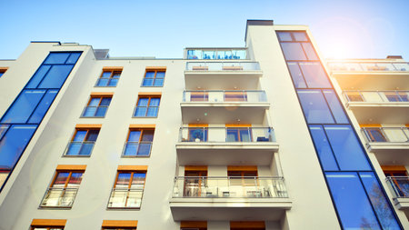 Apartment building with symmetrical modern architecture in the city. Modern apartment building on a sunny day. Facade of a modern apartment building. Bottom view.の写真素材