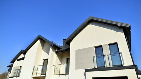 The real estate market in the suburbs. New single family houses in a new development area. Residential homes with modern facade. Terraced family homes in newly developed housingの写真素材