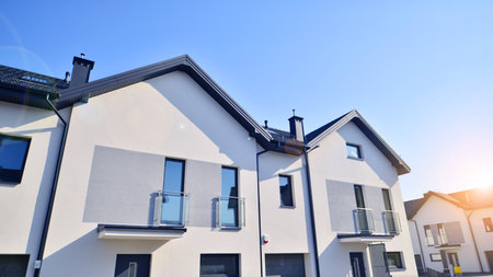 The real estate market in the suburbs. New single family houses in a new development area. Residential homes with modern facade. Terraced family homes in newly developed housingの写真素材