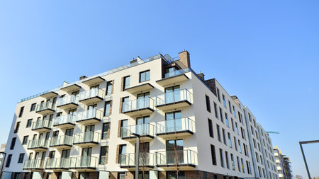 Apartment building with symmetrical modern architecture in the city. Modern apartment building on a sunny day. Facade of a modern apartment building. Bottom view.の写真素材