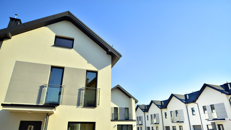 The real estate market in the suburbs. New single family houses in a new development area. Residential homes with modern facade. Terraced family homes in newly developed housingの写真素材