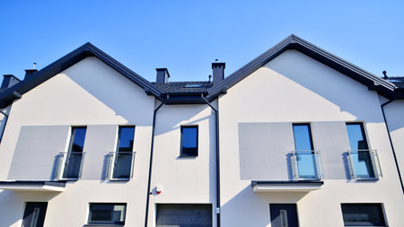 The real estate market in the suburbs. New single family houses in a new development area. Residential homes with modern facade. Terraced family homes in newly developed housingの写真素材