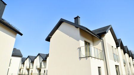 The real estate market in the suburbs. New single family houses in a new development area. Residential homes with modern facade. Terraced family homes in newly developed housingの写真素材