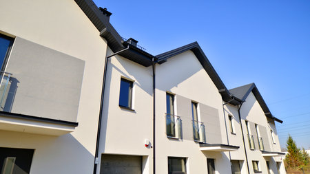 The real estate market in the suburbs. New single family houses in a new development area. Residential homes with modern facade. Terraced family homes in newly developed housingの写真素材