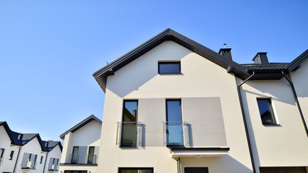 The real estate market in the suburbs. New single family houses in a new development area. Residential homes with modern facade. Terraced family homes in newly developed housingの写真素材
