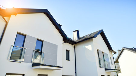 The real estate market in the suburbs. New single family houses in a new development area. Residential homes with modern facade. Terraced family homes in newly developed housingの写真素材