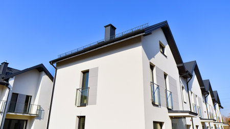 The real estate market in the suburbs. New single family houses in a new development area. Residential homes with modern facade. Terraced family homes in newly developed housingの写真素材