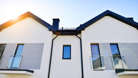 The real estate market in the suburbs. New single family houses in a new development area. Residential homes with modern facade. Terraced family homes in newly developed housingの写真素材