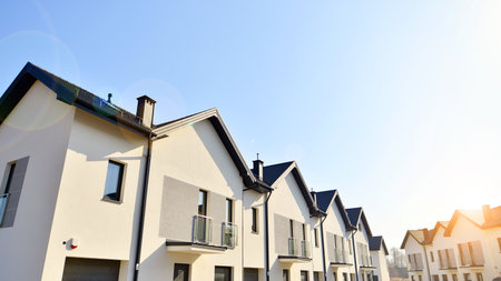 The real estate market in the suburbs. New single family houses in a new development area. Residential homes with modern facade. Terraced family homes in newly developed housingの写真素材