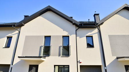 The real estate market in the suburbs. New single family houses in a new development area. Residential homes with modern facade. Terraced family homes in newly developed housingの写真素材