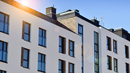 Apartment building with symmetrical modern architecture in the city. Modern apartment building on a sunny day. Facade of a modern apartment building. Bottom view.の写真素材