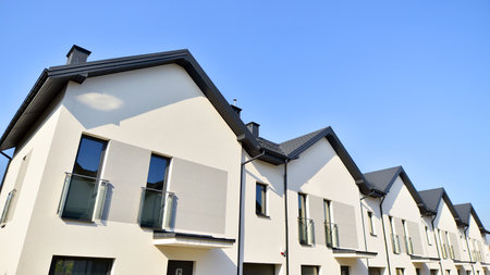 The real estate market in the suburbs. New single family houses in a new development area. Residential homes with modern facade. Terraced family homes in newly developed housingの写真素材