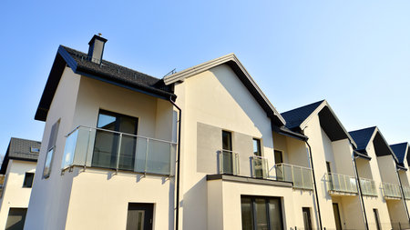 The real estate market in the suburbs. New single family houses in a new development area. Residential homes with modern facade. Terraced family homes in newly developed housingの写真素材