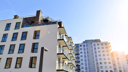 Apartment building with symmetrical modern architecture in the city. Modern apartment building on a sunny day. Facade of a modern apartment building. Bottom view.の写真素材