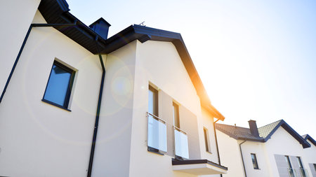 The real estate market in the suburbs. New single family houses in a new development area. Residential homes with modern facade. Terraced family homes in newly developed housingの写真素材
