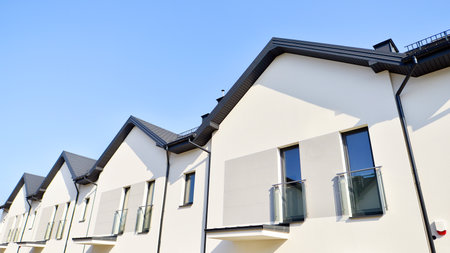 The real estate market in the suburbs. New single family houses in a new development area. Residential homes with modern facade. Terraced family homes in newly developed housingの写真素材