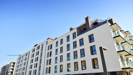 Apartment building with symmetrical modern architecture in the city. Modern apartment building on a sunny day. Facade of a modern apartment building. Bottom view.の写真素材