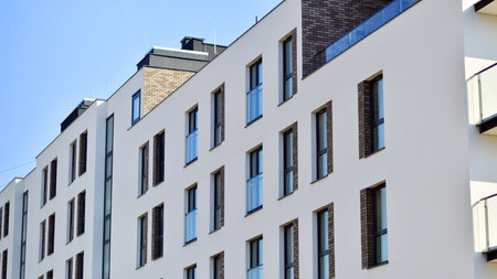 Apartment building with symmetrical modern architecture in the city. Modern apartment building on a sunny day. Facade of a modern apartment building. Bottom view.の写真素材