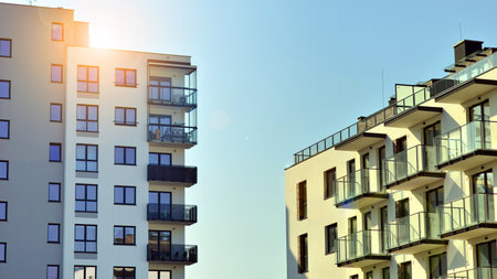 Apartment building with symmetrical modern architecture in the city. Modern apartment building on a sunny day. Facade of a modern apartment building. Bottom view.の写真素材
