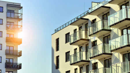 Apartment building with symmetrical modern architecture in the city. Modern apartment building on a sunny day. Facade of a modern apartment building. Bottom view.の写真素材