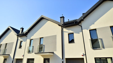 The real estate market in the suburbs. New single family houses in a new development area. Residential homes with modern facade. Terraced family homes in newly developed housingの写真素材