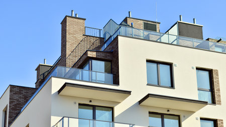 Apartment building with symmetrical modern architecture in the city. Modern apartment building on a sunny day. Facade of a modern apartment building. Bottom view.の写真素材