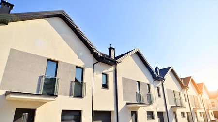 The real estate market in the suburbs. New single family houses in a new development area. Residential homes with modern facade. Terraced family homes in newly developed housingの写真素材
