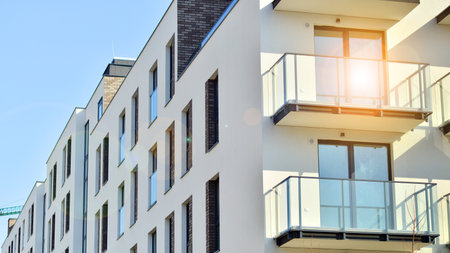 Apartment building with symmetrical modern architecture in the city. Modern apartment building on a sunny day. Facade of a modern apartment building. Bottom view.の写真素材