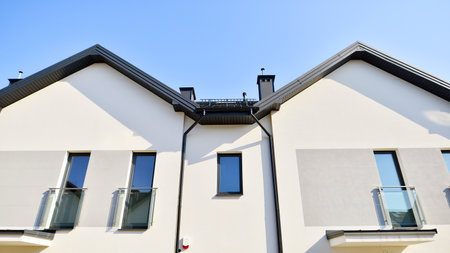 The real estate market in the suburbs. New single family houses in a new development area. Residential homes with modern facade. Terraced family homes in newly developed housingの写真素材