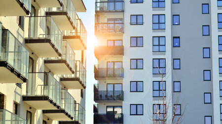 Apartment building with symmetrical modern architecture in the city. Modern apartment building on a sunny day. Facade of a modern apartment building. Bottom view.の写真素材