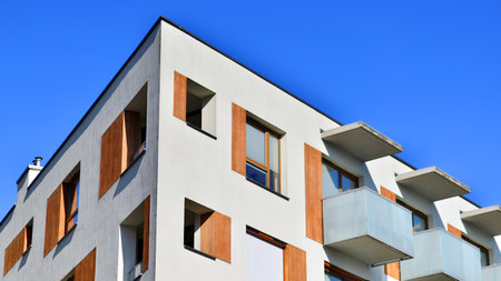 Apartment building with symmetrical modern architecture in the city. Modern apartment building on a sunny day. Facade of a modern apartment building. Bottom view.の写真素材