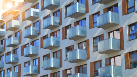 Apartment building with symmetrical modern architecture in the city. Modern apartment building on a sunny day. Facade of a modern apartment building. Bottom view.の写真素材