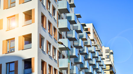 Apartment building with symmetrical modern architecture in the city. Modern apartment building on a sunny day. Facade of a modern apartment building. Bottom view.の写真素材