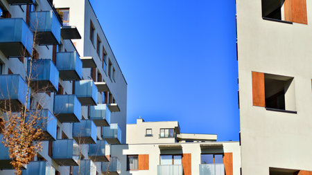 Apartment building with symmetrical modern architecture in the city. Modern apartment building on a sunny day. Facade of a modern apartment building. Bottom view.の写真素材