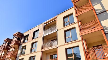 New apartment building. Residential area with modern apartment building. in sunny day. Fragments of the wooden facade.の写真素材